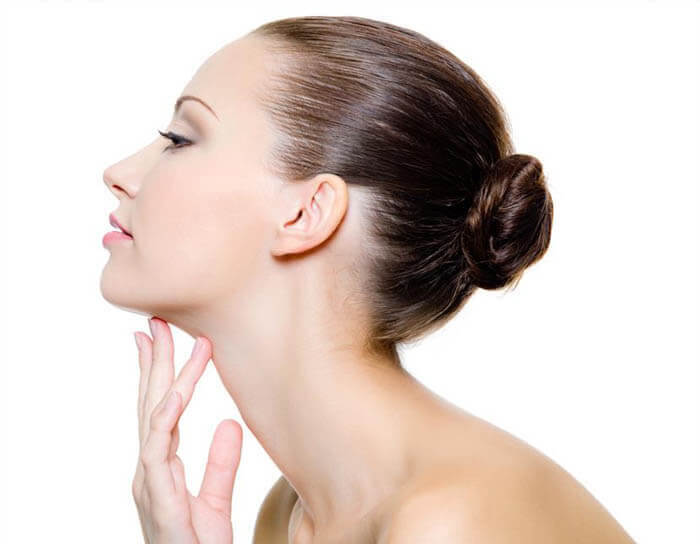 Picture of a woman with her hand to her neck showing her neck liposuction procedure in Costa Rica.